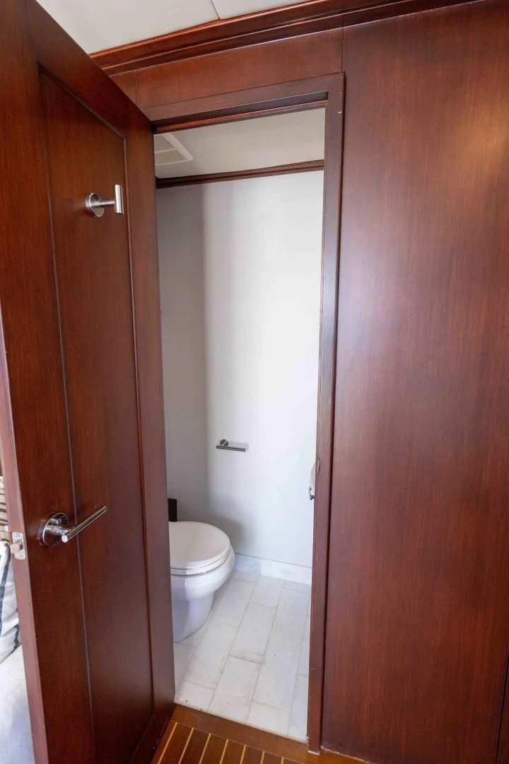 a bathroom with a toilet and a wooden door aboard ARIES Yacht for Sale