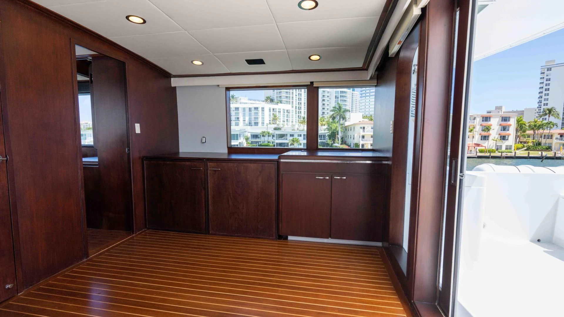 a room with a wood floor and a large window with a view of a city aboard ARIES Yacht for Sale