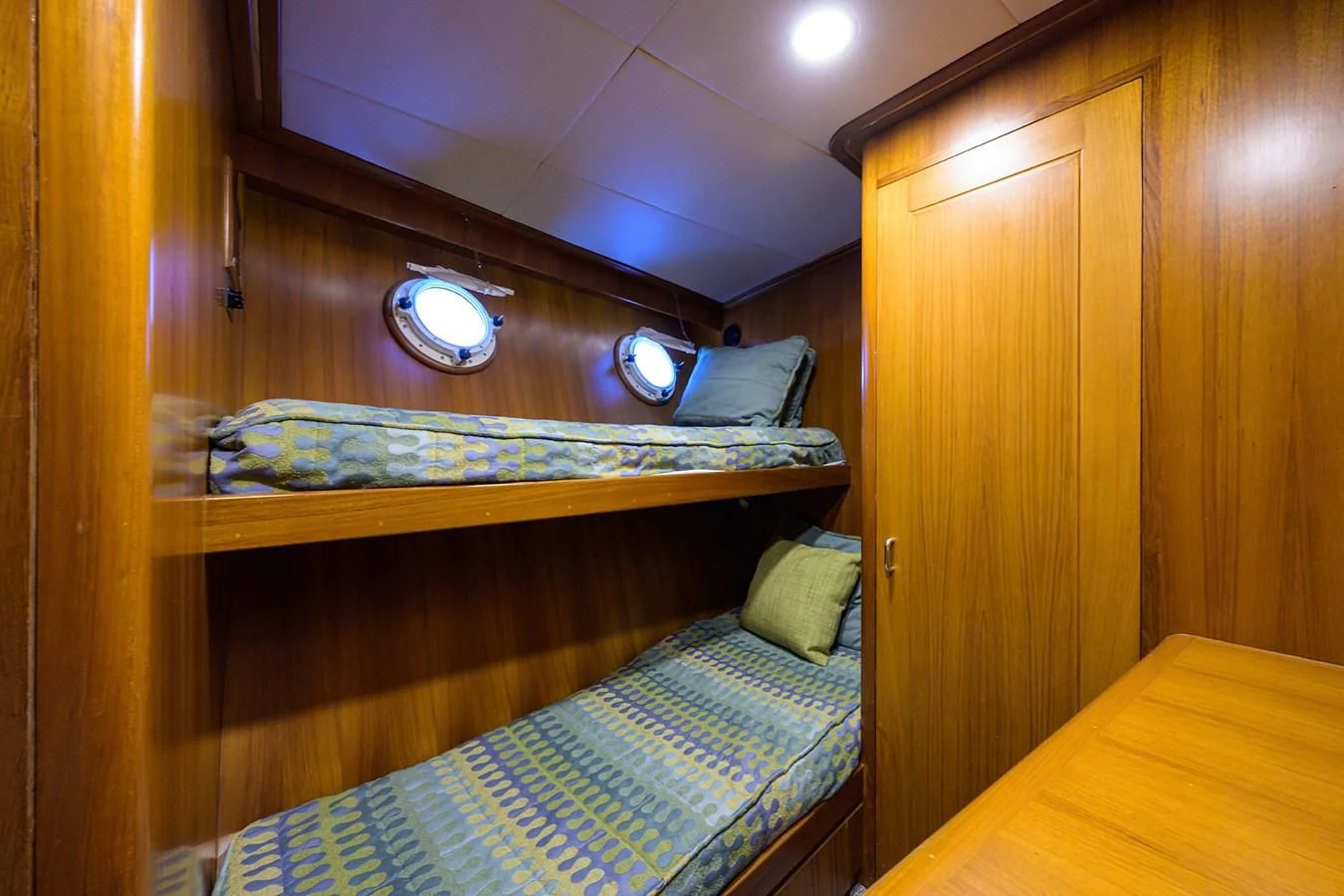 a bed with a blue comforter aboard ARIES Yacht for Sale