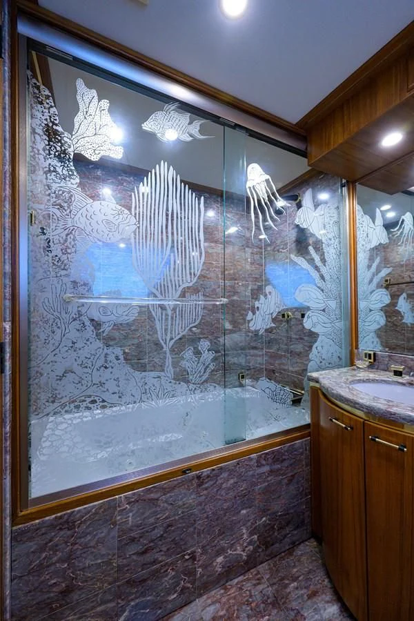 a bathroom with a large glass shower aboard ARIES Yacht for Sale