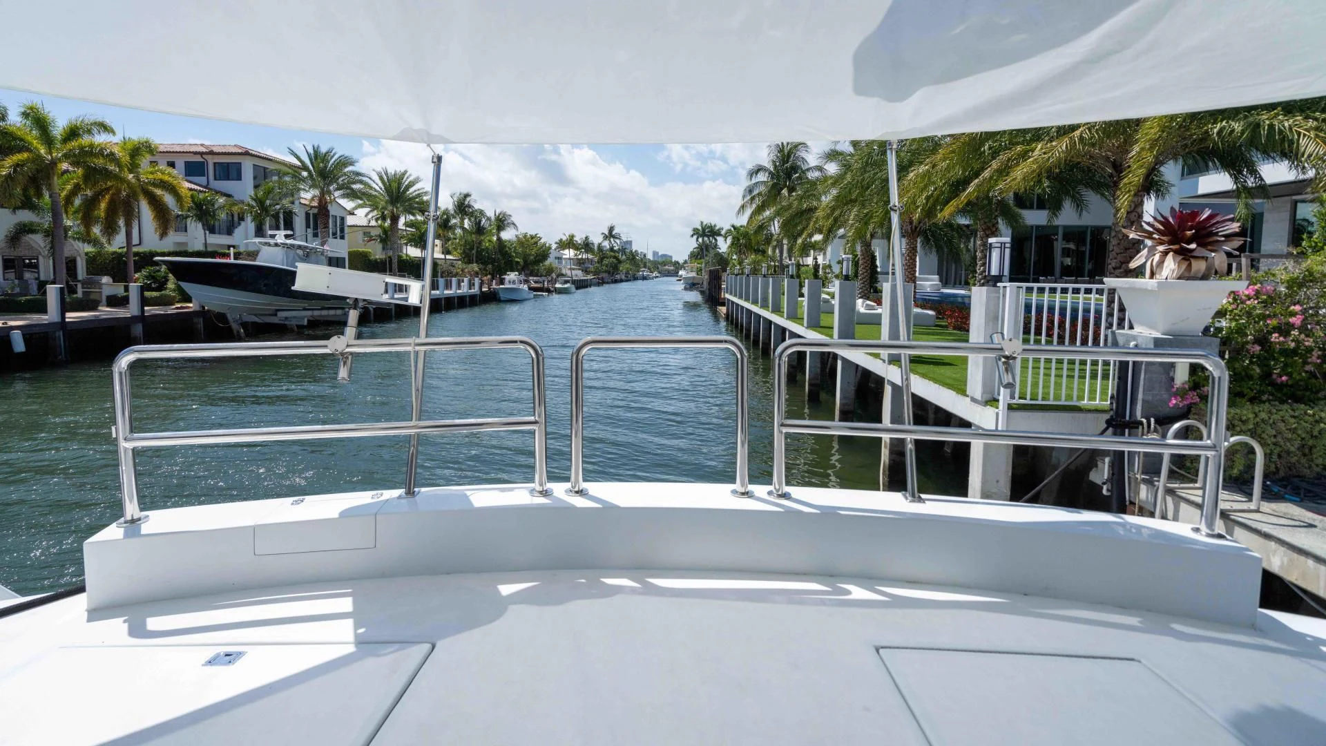 a pool with a deck and a pool with trees and buildings in the background aboard ARIES Yacht for Sale