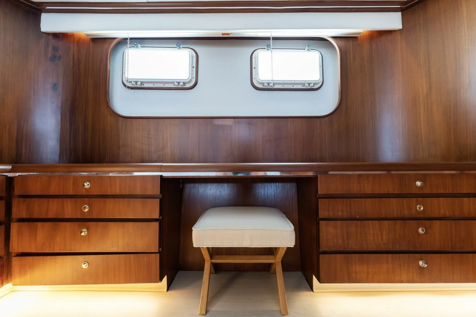 a wooden cabinet with a stool aboard ARIES Yacht for Sale