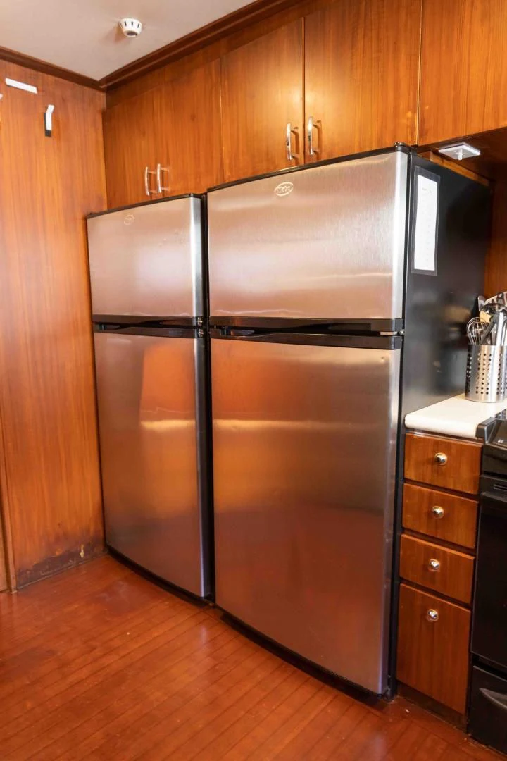 a kitchen with a stainless steel refrigerator aboard ARIES Yacht for Sale