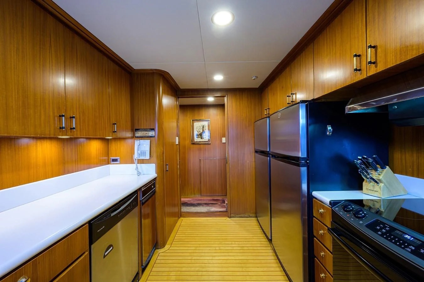 a kitchen with wooden cabinets aboard ARIES Yacht for Sale