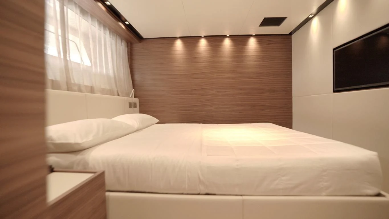 a bed with white sheets aboard SUPERNOVA Yacht for Sale