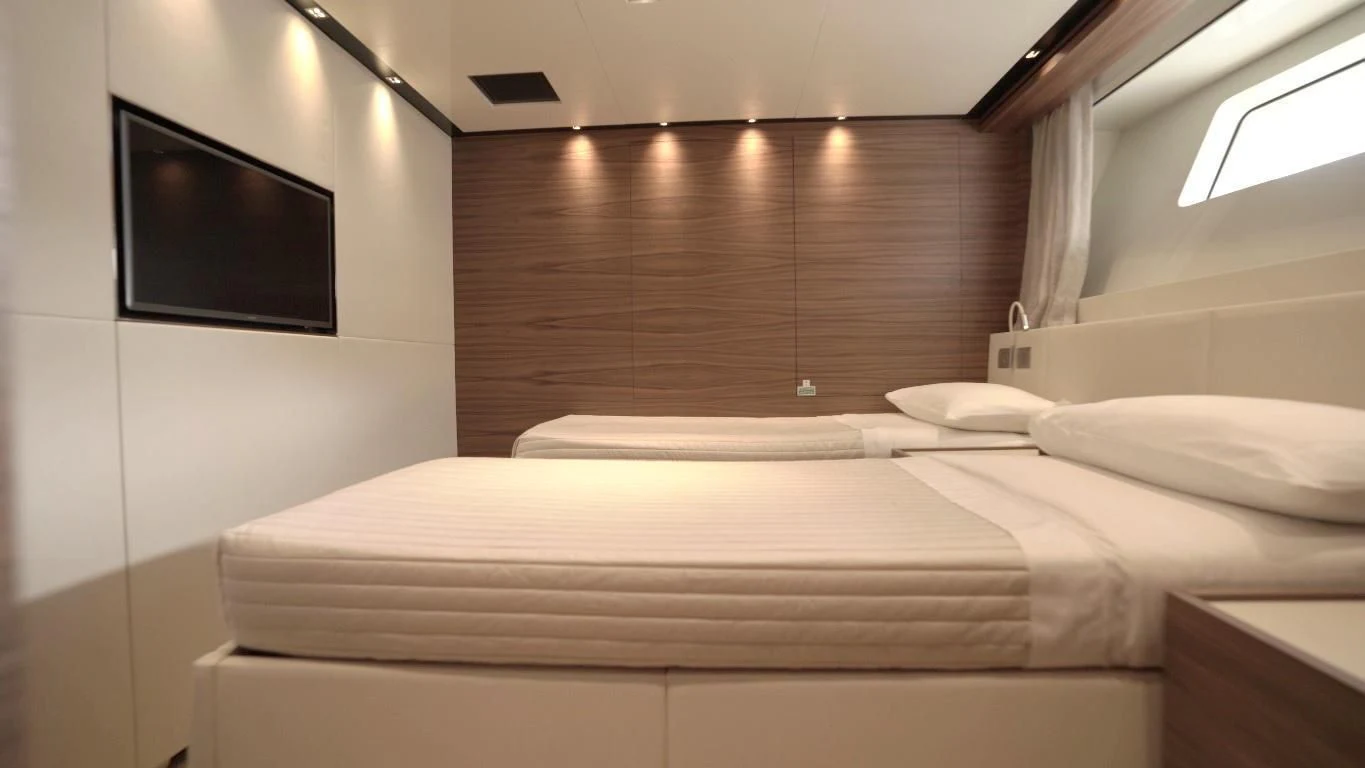 a bed with a television on the wall aboard SUPERNOVA Yacht for Sale