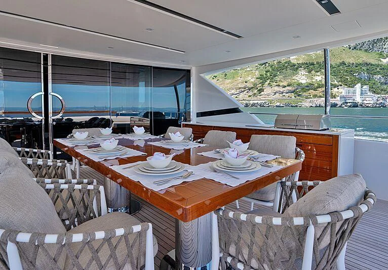 a dining table with chairs and a view of the water aboard SUPERNOVA Yacht for Sale