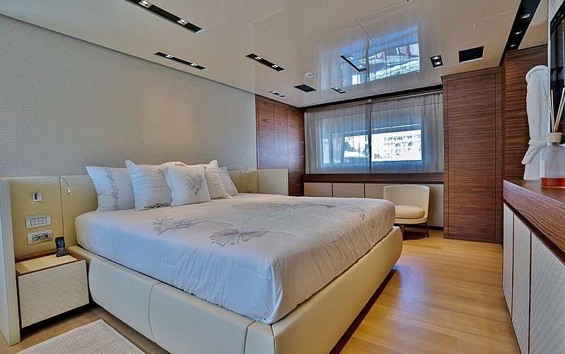 a bedroom with a bed and a desk aboard SUPERNOVA Yacht for Sale