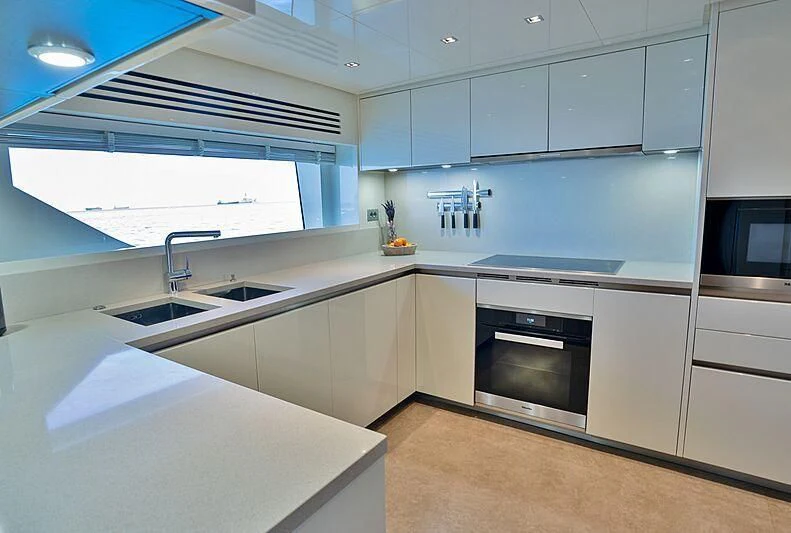 a kitchen with white cabinets aboard SUPERNOVA Yacht for Sale