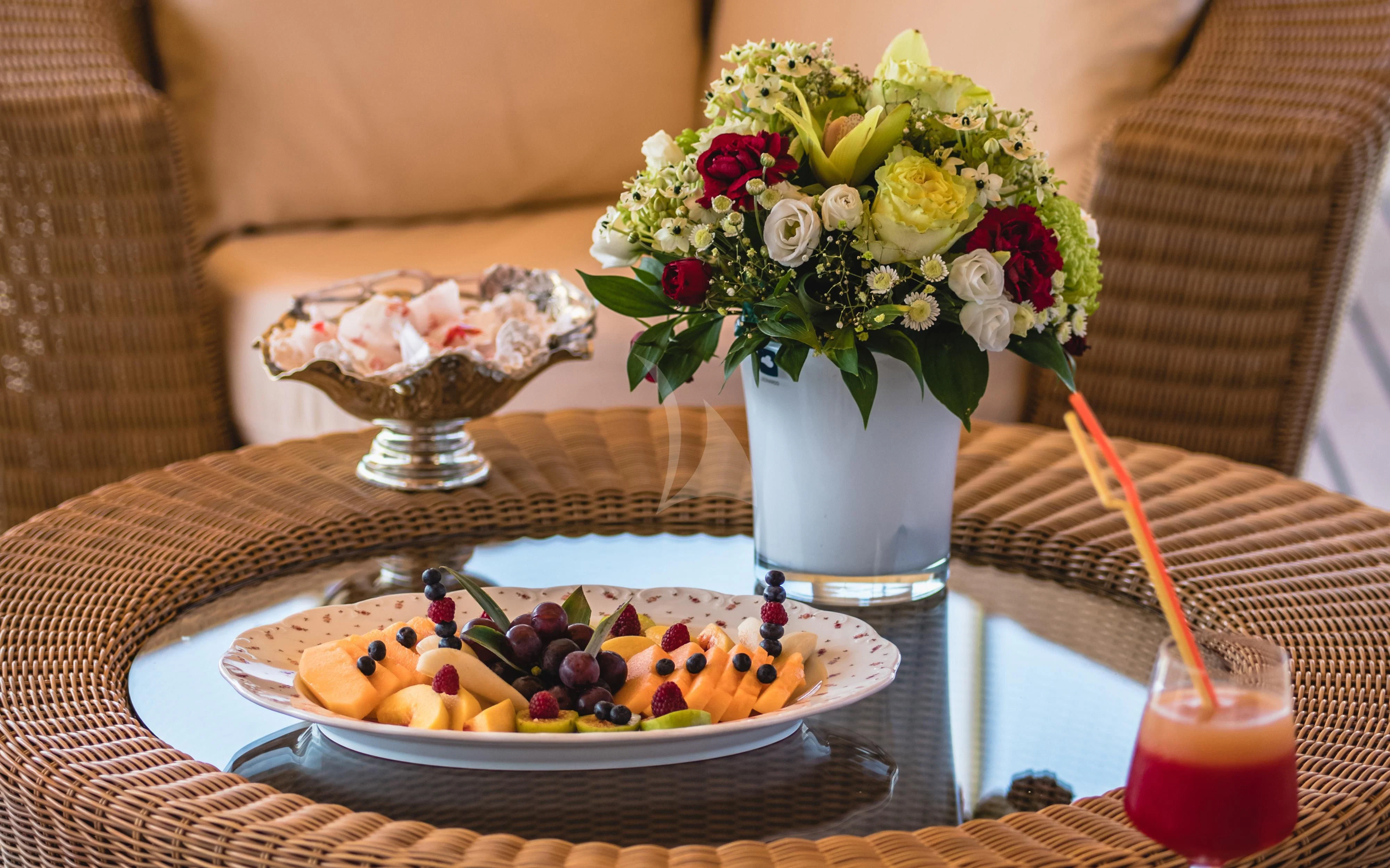 a plate of food and a glass of juice on a table aboard SEAGULL II Yacht for Sale