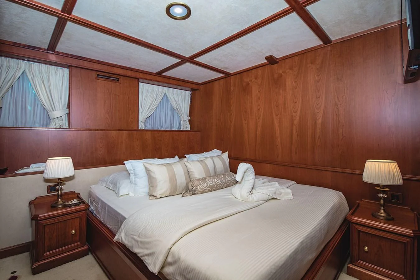 a bed with a white sheet and a lamp on it aboard SEAGULL II Yacht for Sale