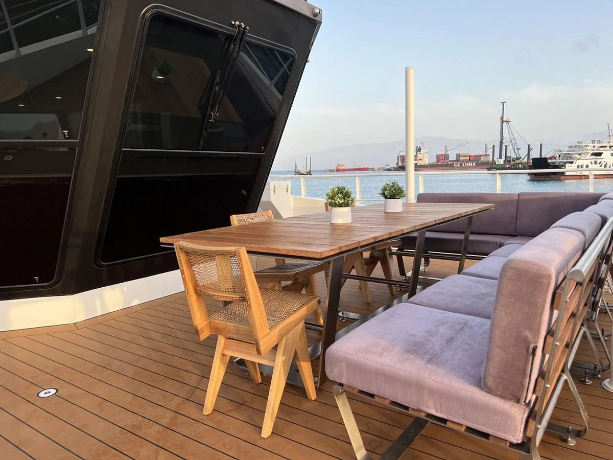 a table and chairs on a deck aboard BAD COMPANY SUPPORT Yacht for Charter