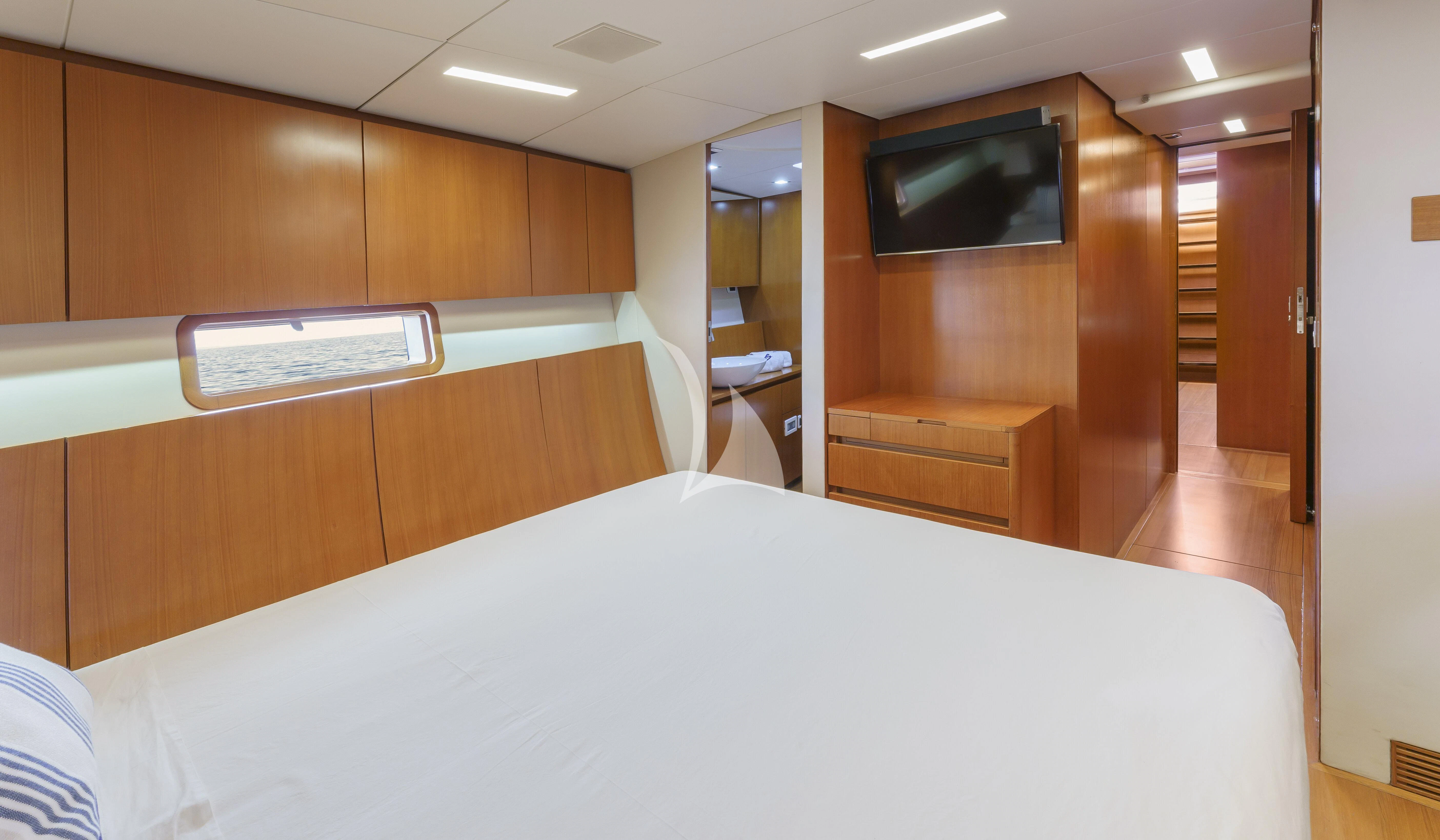 a room with a bed and a television aboard BOMBARDA Yacht for Sale