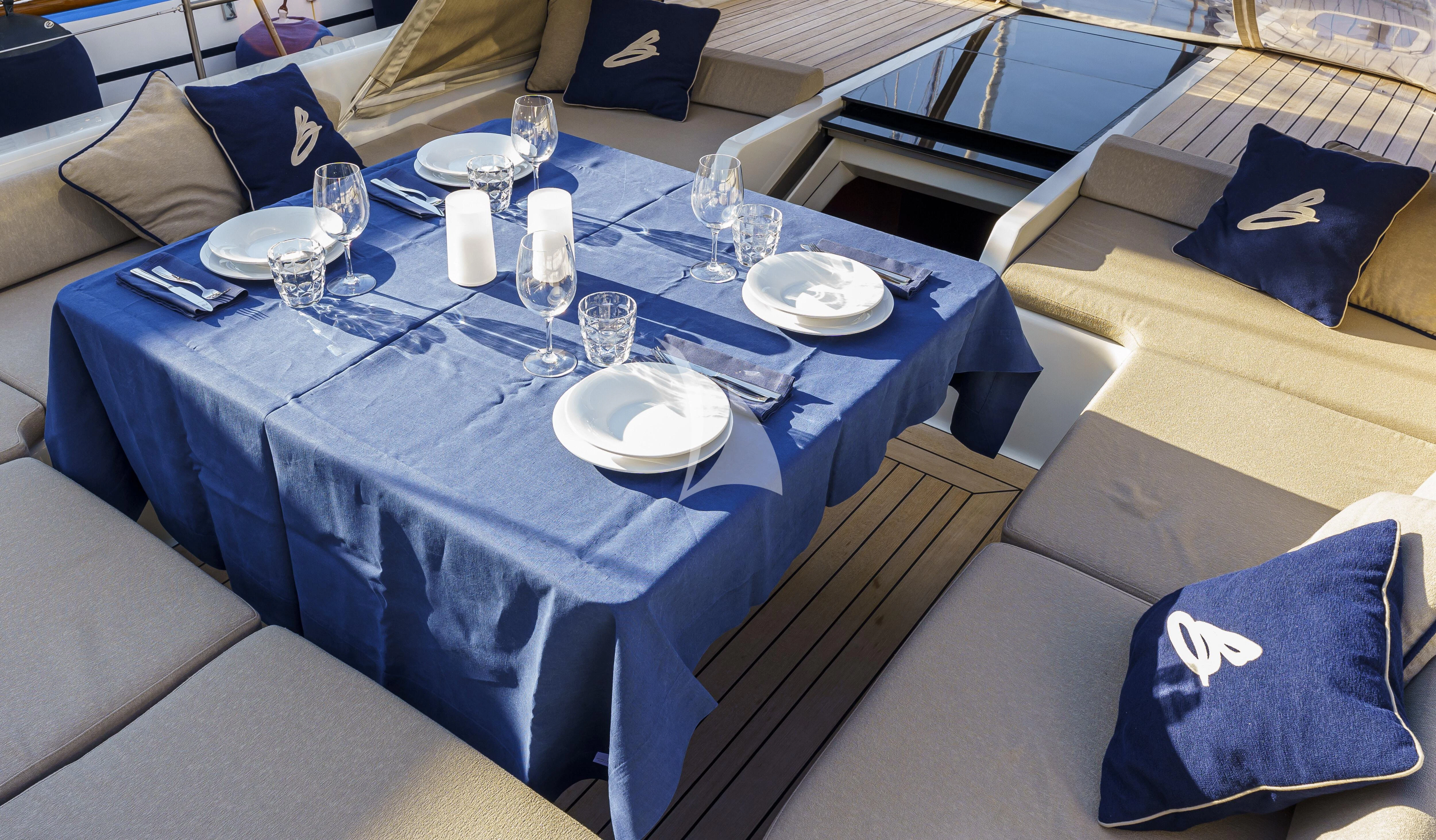 a table with plates and glasses on it aboard BOMBARDA Yacht for Sale