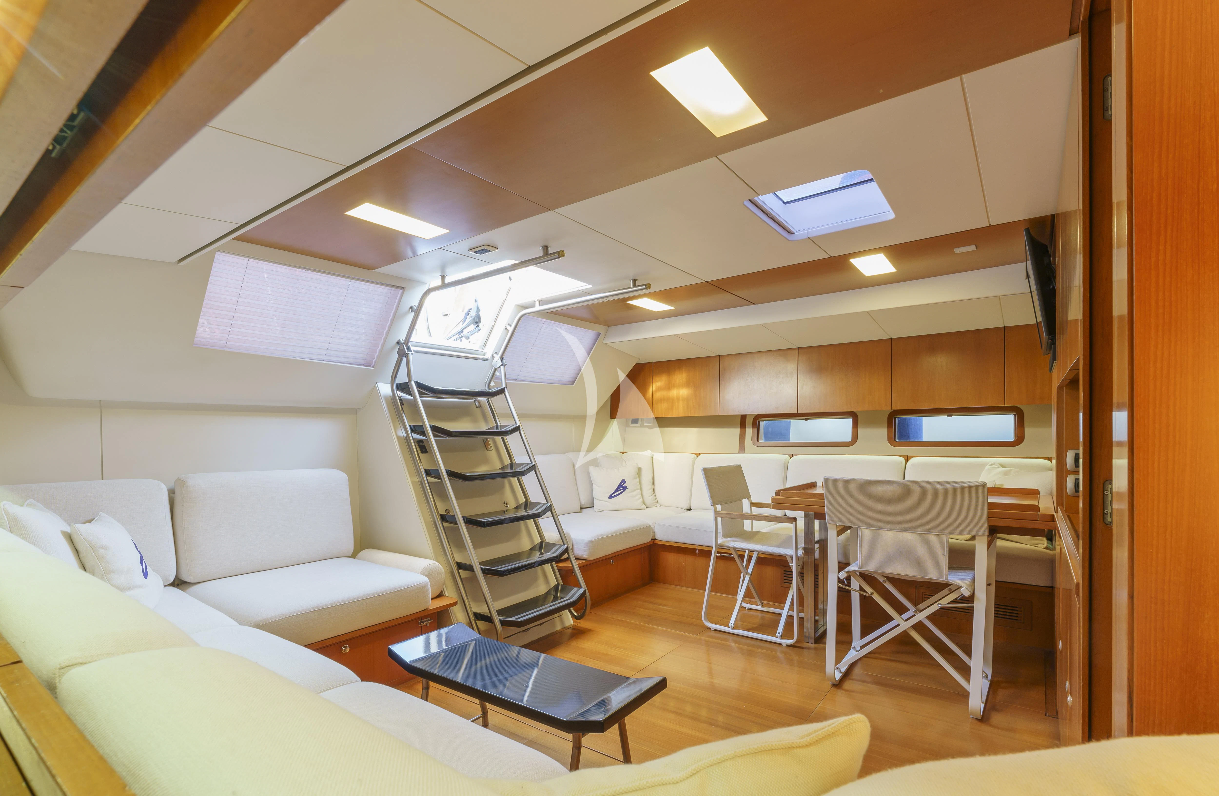a room with a staircase and couches aboard BOMBARDA Yacht for Sale