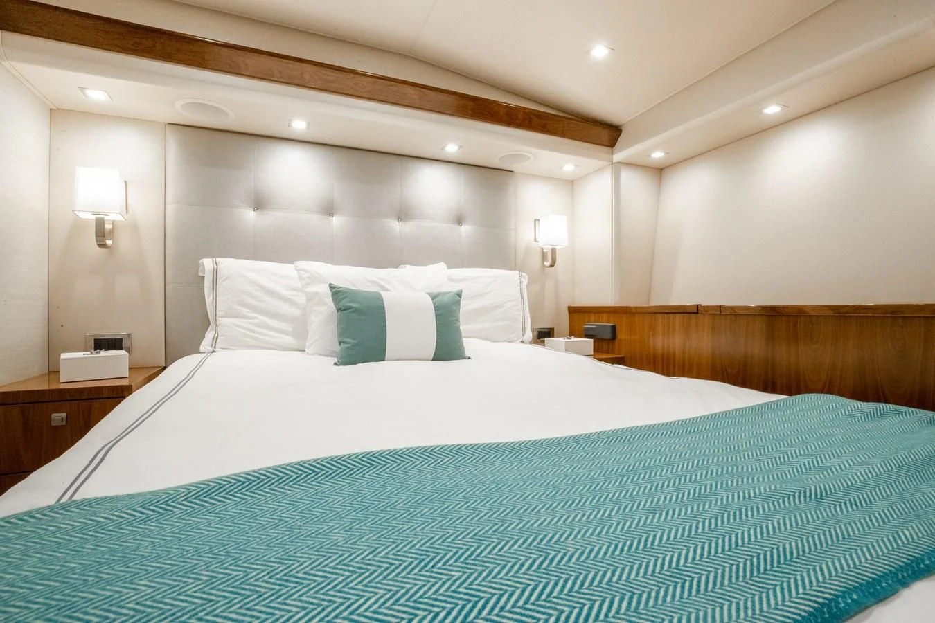a bed with a blue and white comforter and pillows aboard TEUSEAS Yacht for Sale
