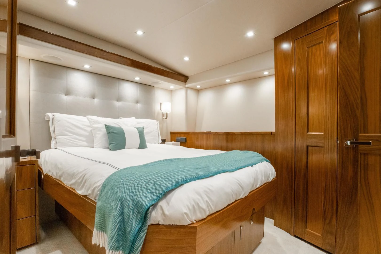 a bedroom with a bed and a wood door aboard TEUSEAS Yacht for Sale