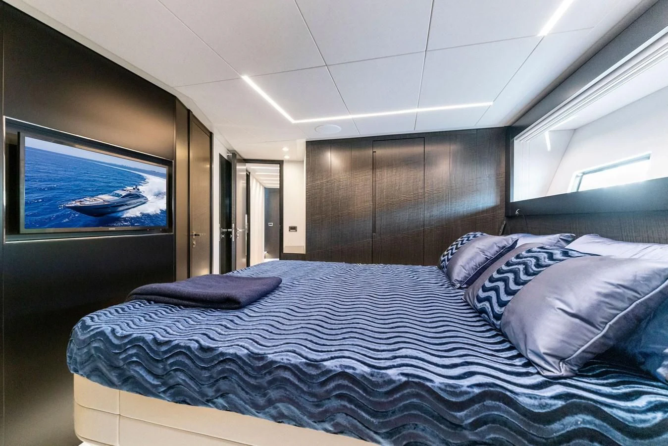 a bed with a blue comforter aboard OUR TRADE Yacht for Sale