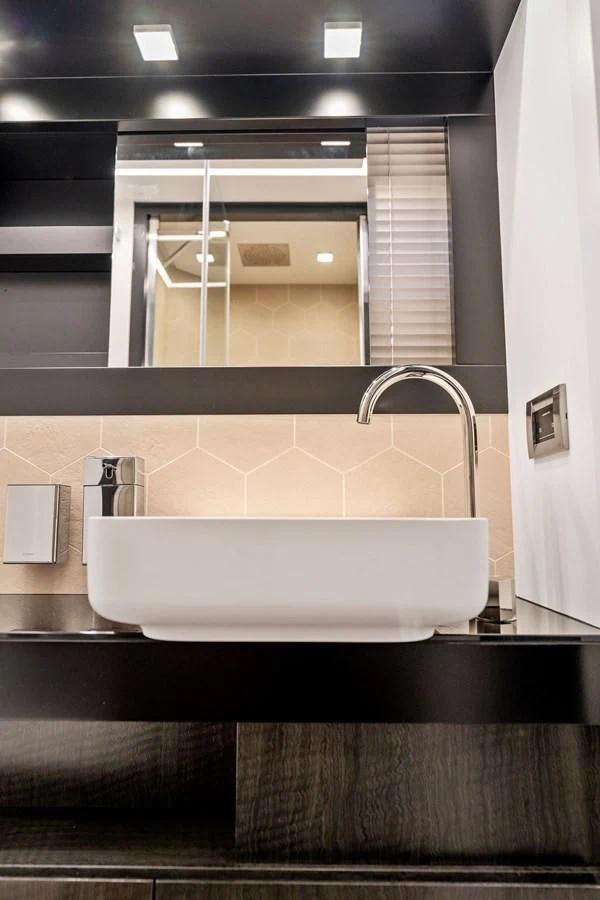 a bathroom sink with a large mirror aboard OUR TRADE Yacht for Sale