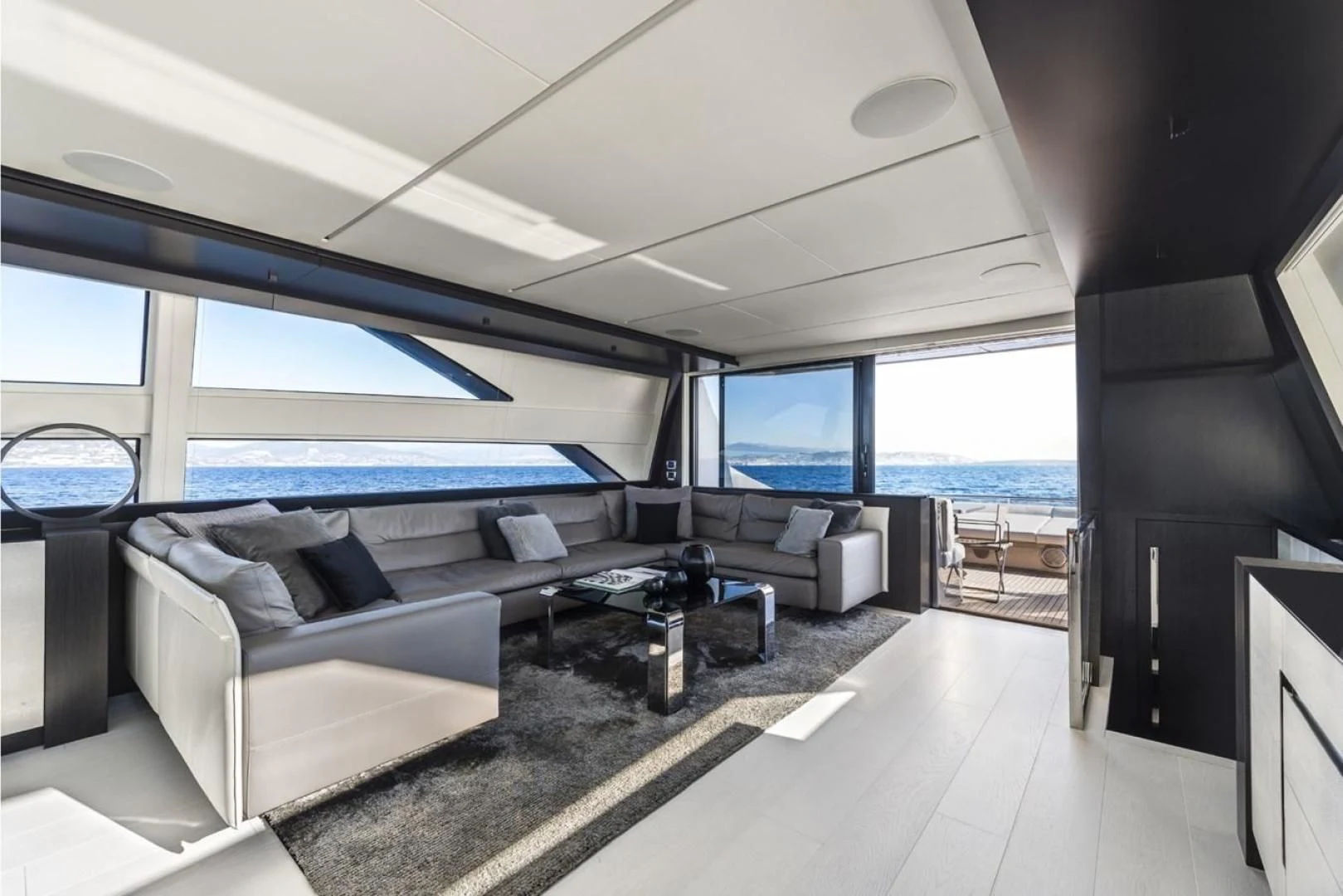 a room with a couch and a table and a large window aboard OUR TRADE Yacht for Sale