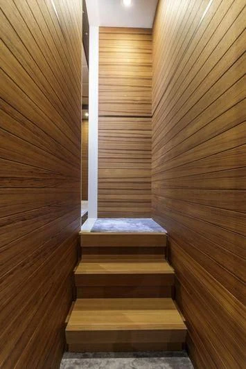 a wooden staircase with a white railing aboard MYSTERE Yacht for Sale