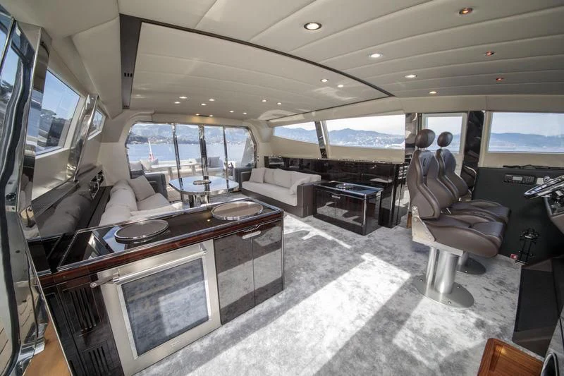inside of a vehicle with a large screen and a table with chairs aboard MYSTERE Yacht for Sale