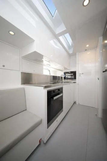 a white kitchen with a black stove aboard MYSTERE Yacht for Sale
