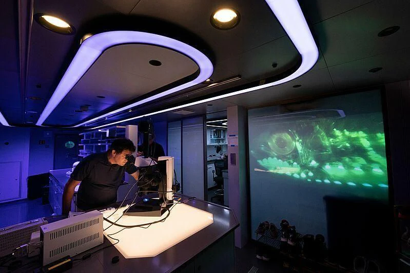 a man in a room with a large aquarium aboard OCEANXPLORER 1 Yacht for Sale