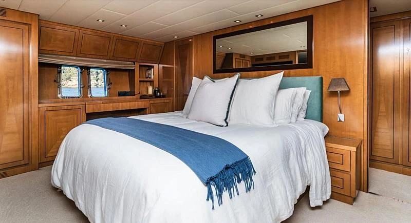 a bed with blue sheets aboard PALOMA Yacht for Sale