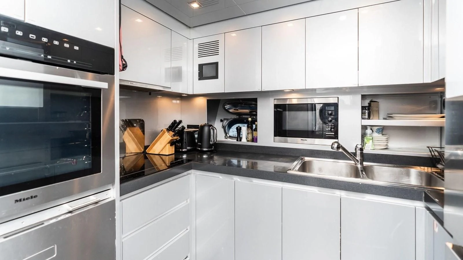 a kitchen with white cabinets aboard PALOMA Yacht for Sale
