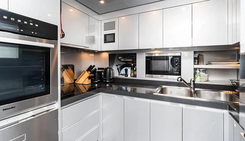 a kitchen with white cabinets aboard PALOMA Yacht for Sale