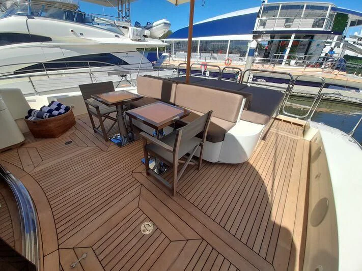 a deck with a view of the water and a boat aboard PALOMA Yacht for Sale