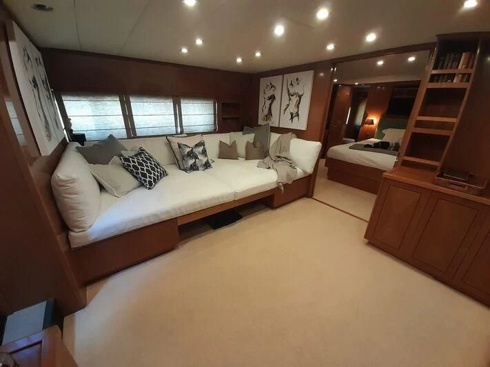 a bedroom with a bed and a bookcase aboard PALOMA Yacht for Sale