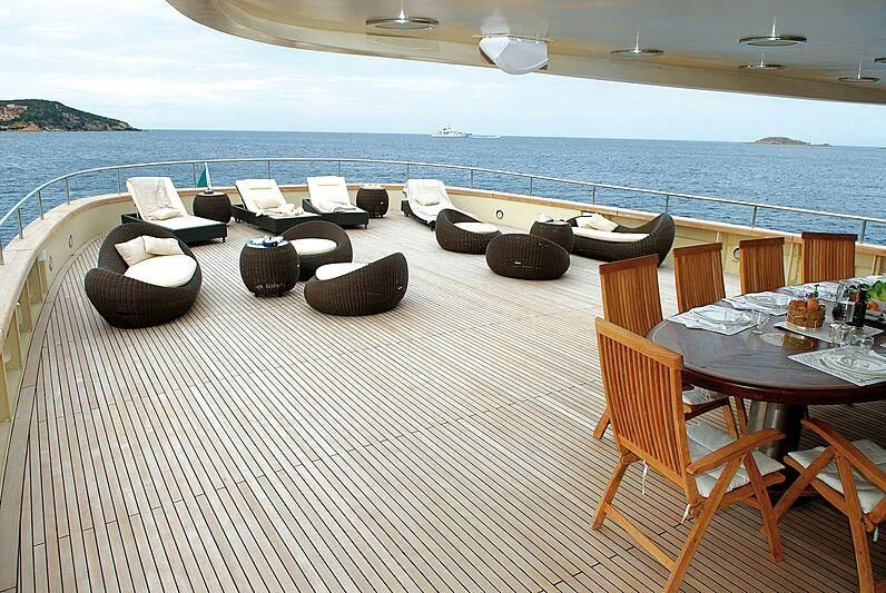 a deck with chairs and tables on it by the water aboard DADDY SHANE Yacht for Sale