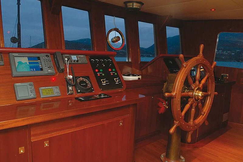 a wooden desk with a large wooden chair and a large wooden wheel aboard DADDY SHANE Yacht for Sale
