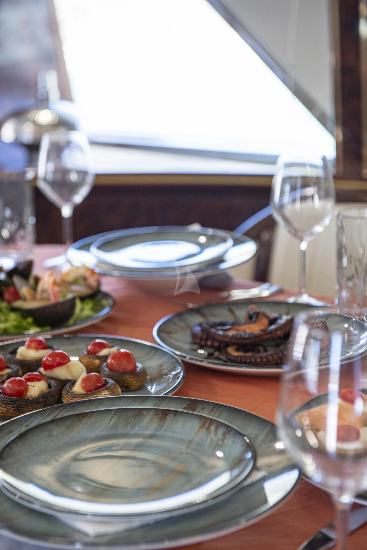 a table with plates of food and glasses on it aboard WISH Yacht for Sale