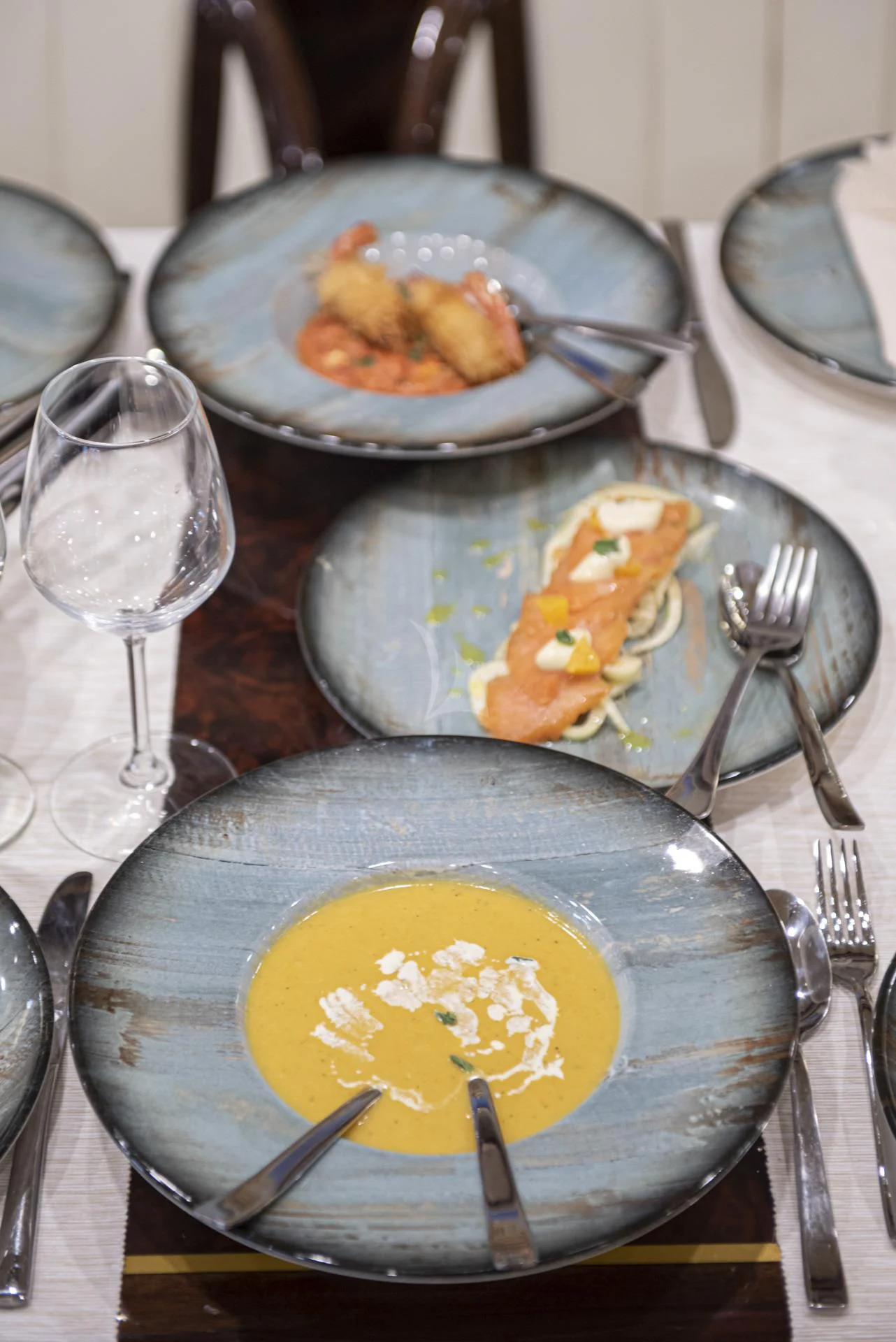 a table with plates of food and silverware aboard WISH Yacht for Sale