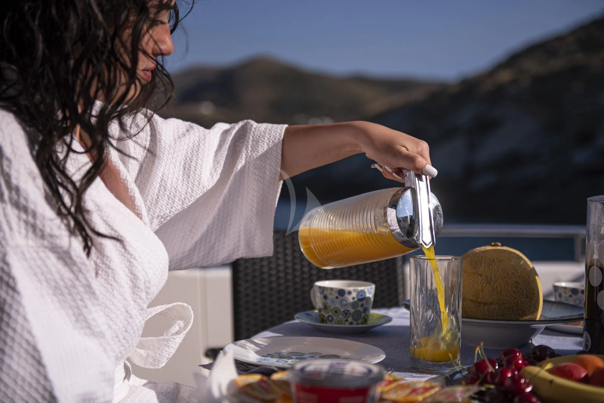 a person pouring a drink into a glass aboard WISH Yacht for Sale