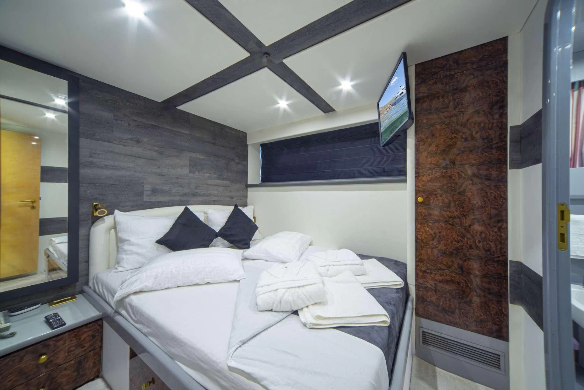 a room with a bed and a television aboard WISH Yacht for Sale