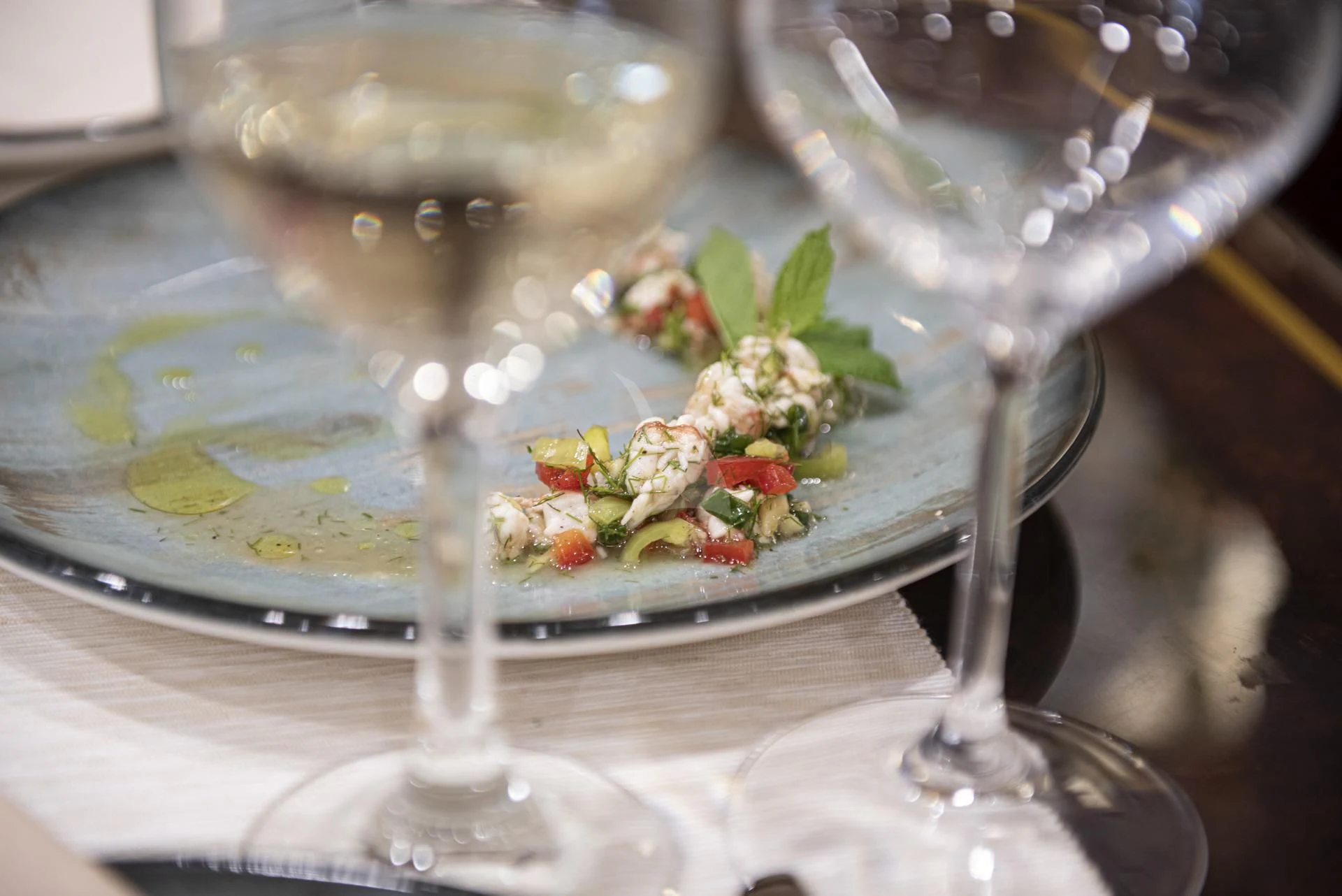 a plate of food and a glass of wine aboard WISH Yacht for Sale