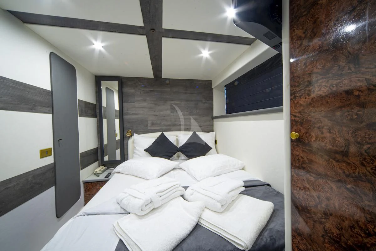 a room with a bed and a wall with a mirror aboard WISH Yacht for Sale