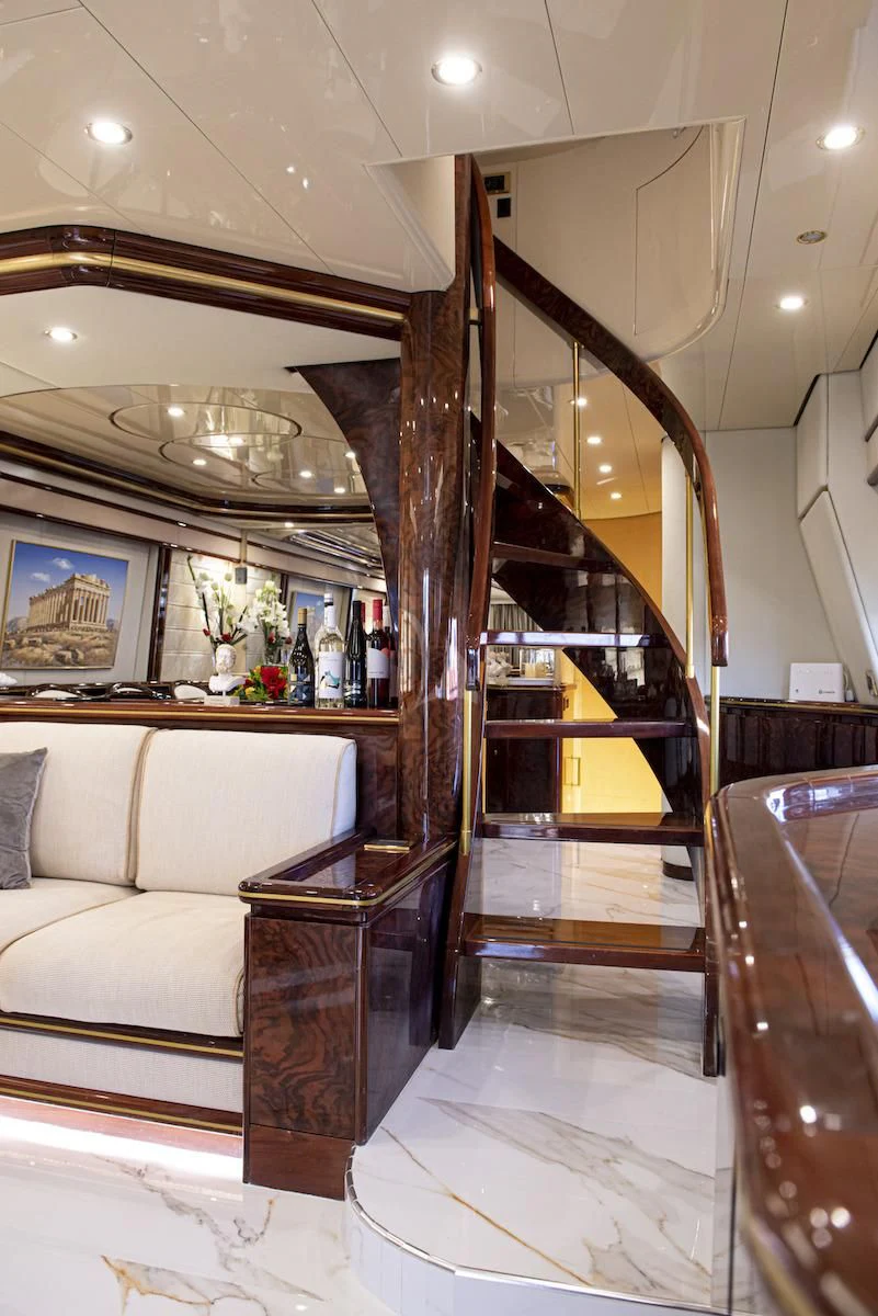 a living room with a wood staircase aboard WISH Yacht for Sale
