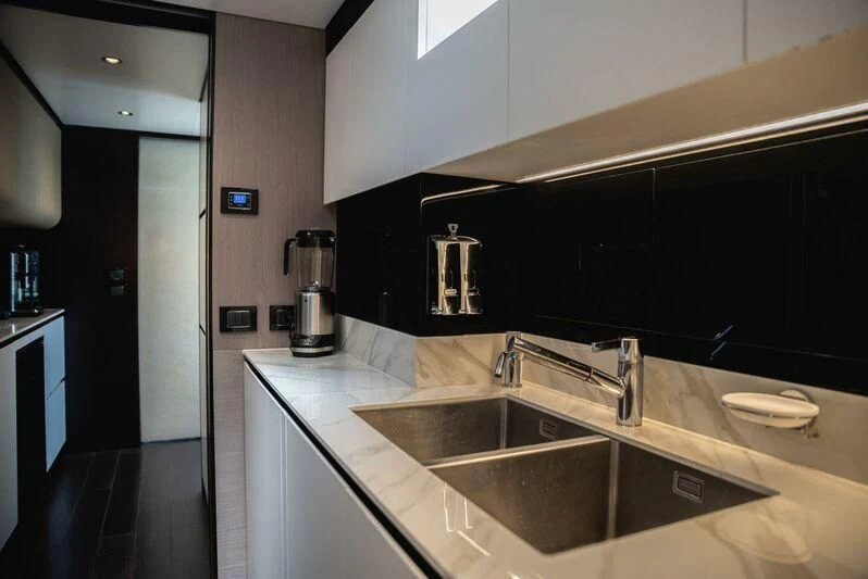 a kitchen with a sink and a refrigerator aboard TAMUSIA Yacht for Sale
