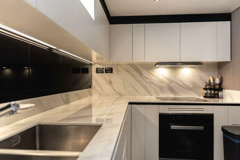 a kitchen with white cabinets aboard TAMUSIA Yacht for Sale