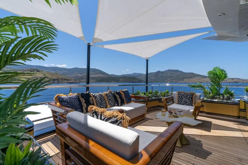 a patio with a couch and a table and a large body of water aboard LEONA Yacht for Sale