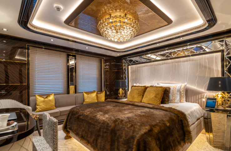 a large room with a bed and a chandelier aboard LEONA Yacht for Sale
