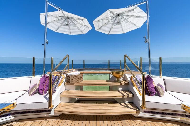 a couple of white lounge chairs on a boat with an umbrella aboard LEONA Yacht for Sale