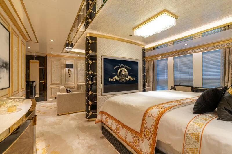 a bedroom with a bed and a painting on the wall aboard LEONA Yacht for Sale