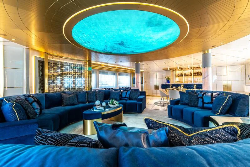 a living room with blue couches aboard LEONA Yacht for Sale