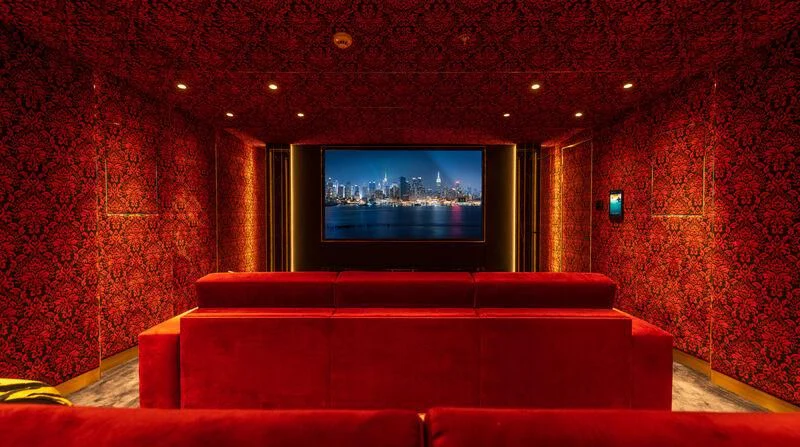 a room with a tv and a red couch aboard LEONA Yacht for Sale